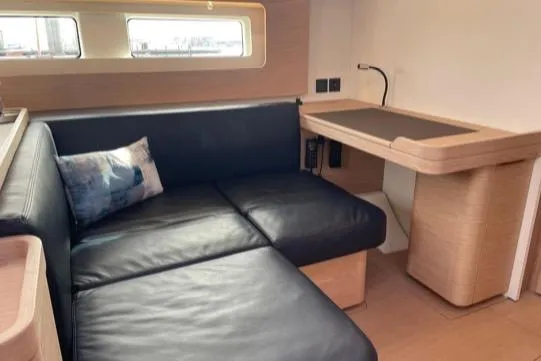 Slide: The Image of Interior of 2022 Beneteau Oceanis Yacht 54 with leather seating and wooden desk. - 46