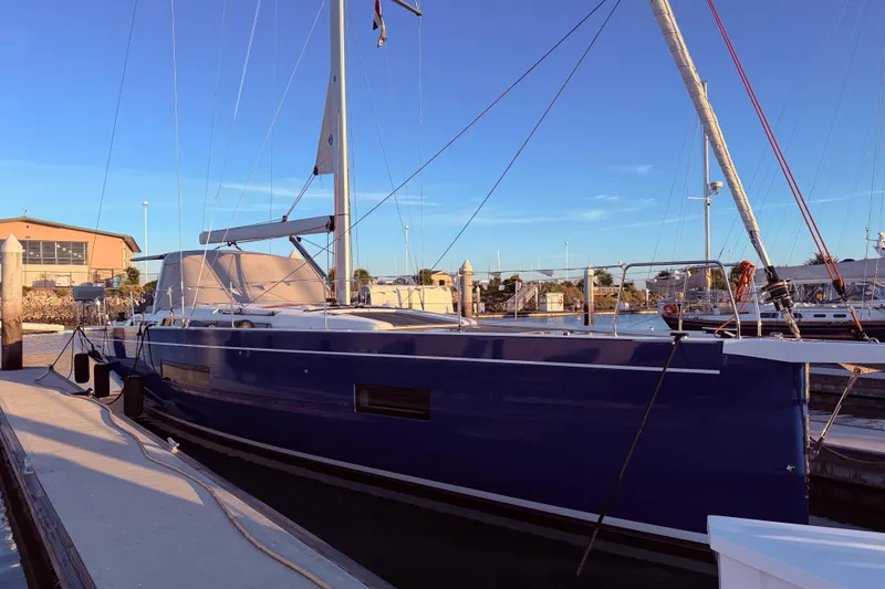 Slide: The Image of 2022 Beneteau Oceanis Yacht 54 docked at marina under clear blue sky. - 5