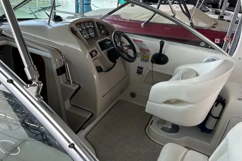 Slide: The Image of 2004 Sea Ray 260 Sundancer cockpit with steering wheel and control panel. - 12