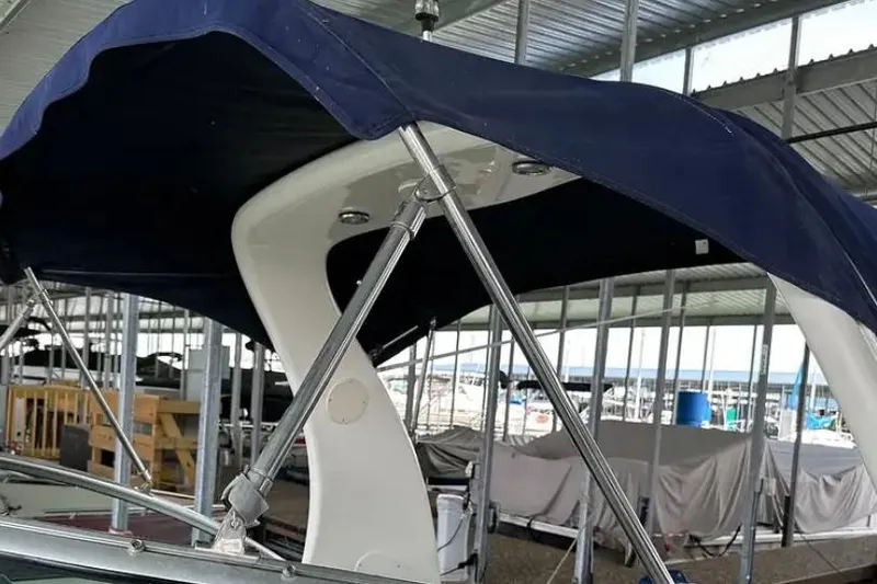 Slide: The Image of 2004 Sea Ray 260 Sundancer boat with blue canopy in marina storage. - 13
