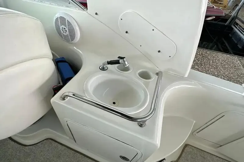 Slide: The Image of 2004 Sea Ray 260 Sundancer boat sink with faucet and storage compartment. - 19