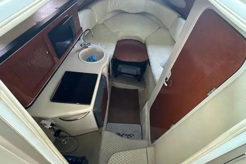 Slide: The Image of 2004 Sea Ray 260 Sundancer cabin interior with kitchenette and seating area. - 26