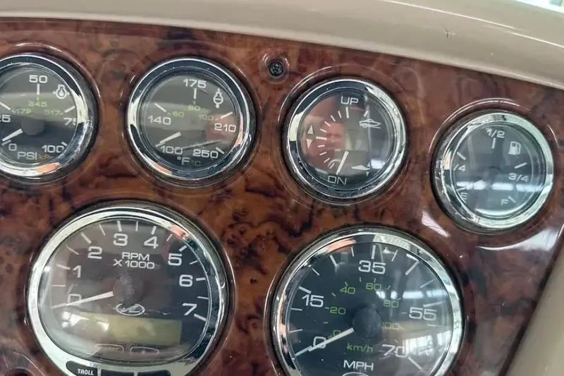 Slide: The Image of Dashboard of a 2004 Sea Ray 260 Sundancer boat with various gauges and indicators. - 28