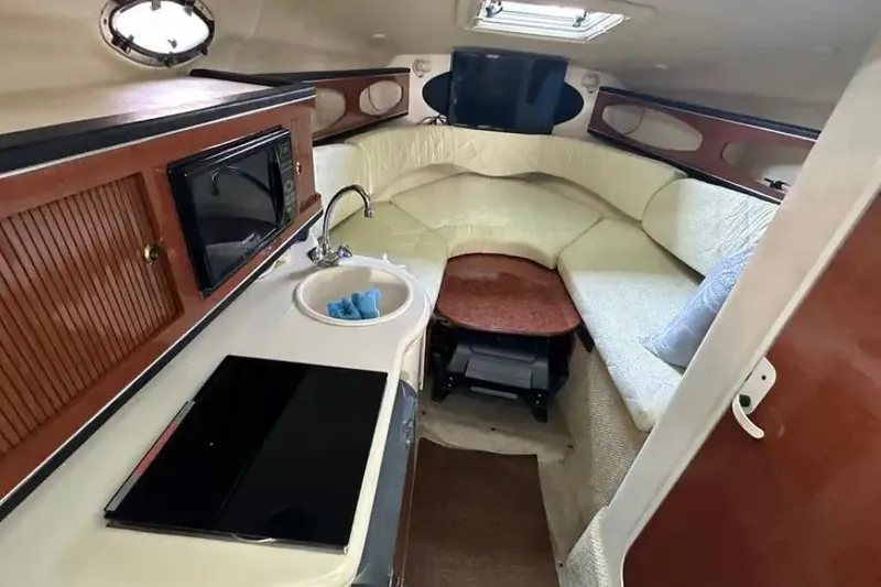 Slide: The Image of Interior of 2004 Sea Ray 260 Sundancer with kitchenette and cozy seating area. - 30