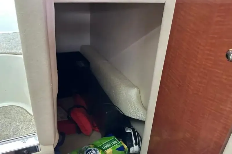 Slide: The Image of Storage compartment inside a 2004 Sea Ray 260 Sundancer boat, featuring various items. - 34
