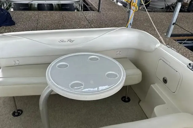 Slide: The Image of 2004 Sea Ray 260 Sundancer boat interior with white seating and round table. - 39