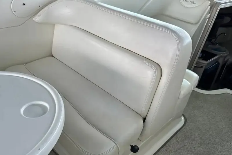 Slide: The Image of Interior seating of 2004 Sea Ray 260 Sundancer boat with white upholstery and table. - 40