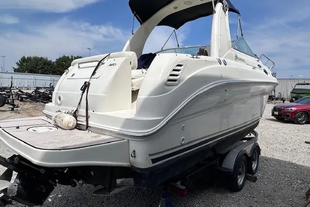 Slide: The Image of 2004 Sea Ray 260 Sundancer boat on trailer, parked outdoors under blue sky. - 47