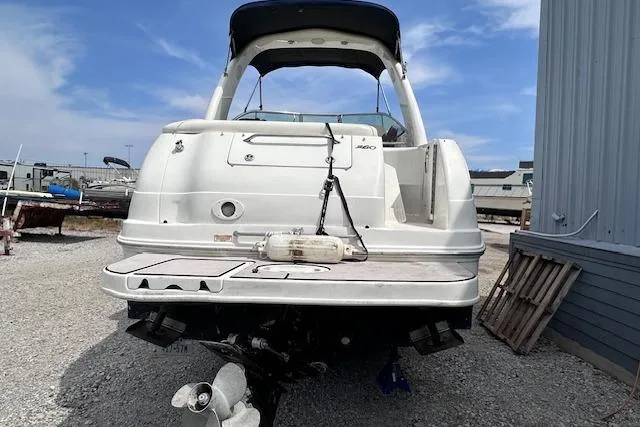 Slide: The Image of 2004 Sea Ray 260 Sundancer boat docked on gravel near a building. - 50