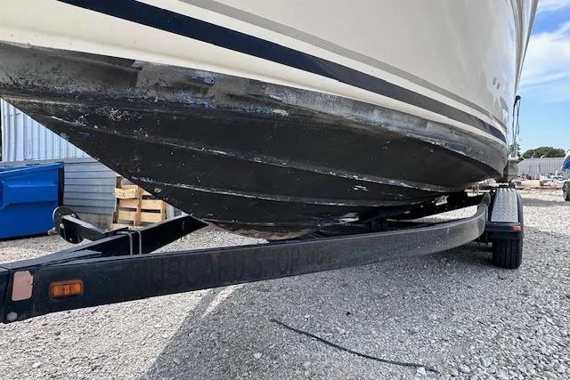 Slide: The Image of 2004 Sea Ray 260 Sundancer boat on trailer, showing hull and surroundings. - 52