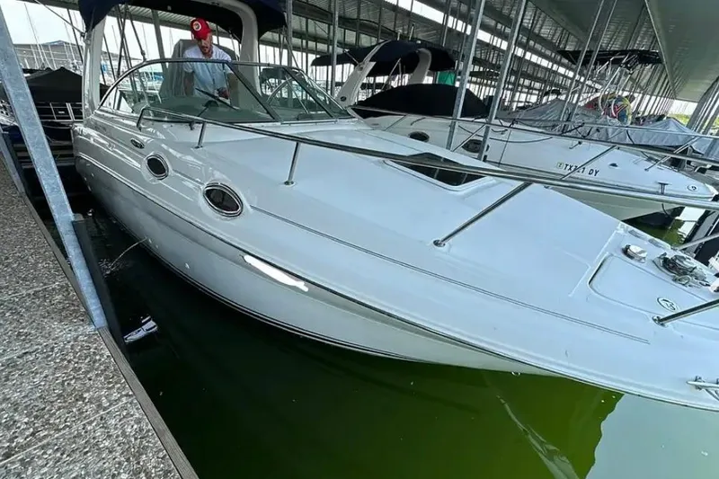 Slide: The Image of 2004 Sea Ray 260 Sundancer docked in a marina, featuring sleek white design. - 6