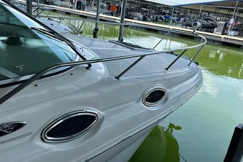 Slide: The Image of 2004 Sea Ray 260 Sundancer docked in a marina, showcasing sleek design and railing. - 9