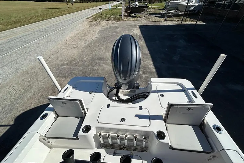 Slide: The Image of 2026 Sea Pro 210 Bay boat with outboard motor, viewed from above, parked on a roadside. - 23