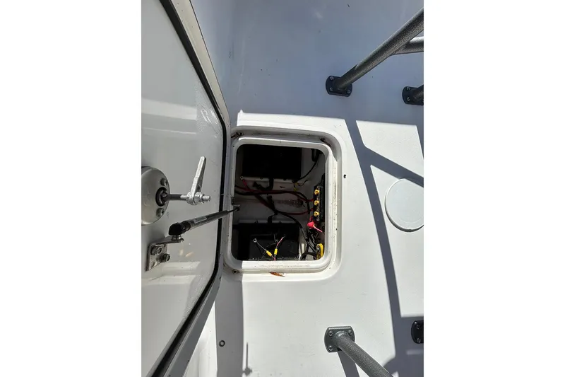 Slide: The Image of Open hatch on 2026 Sea Pro 210 Bay boat, revealing internal wiring and components. - 24