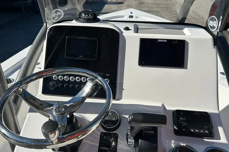 Slide: The Image of 2026 Sea Pro 210 Bay boat dashboard with steering wheel and navigation controls. - 27