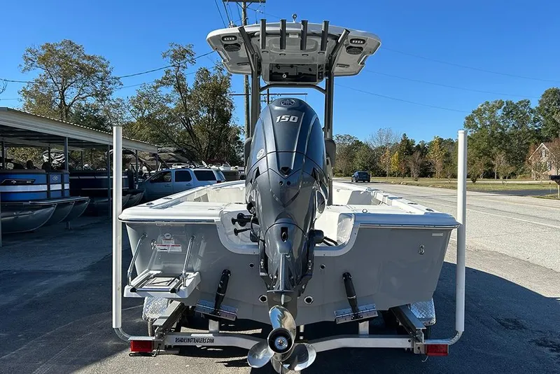 Slide: The Image of 2026 Sea Pro 210 Bay boat with 150 HP engine on trailer, parked outdoors. - 4