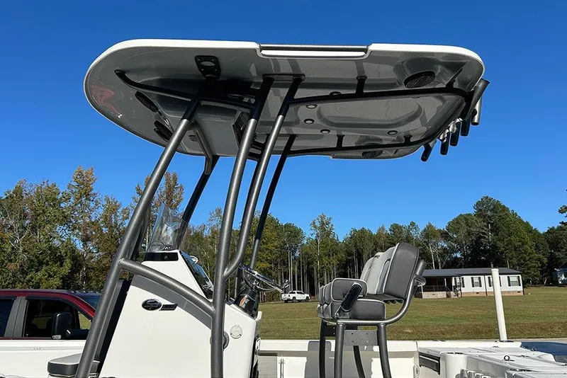 Slide: The Image of 2026 Sea Pro 210 Bay boat with T-top and seating, set against a clear blue sky. - 49