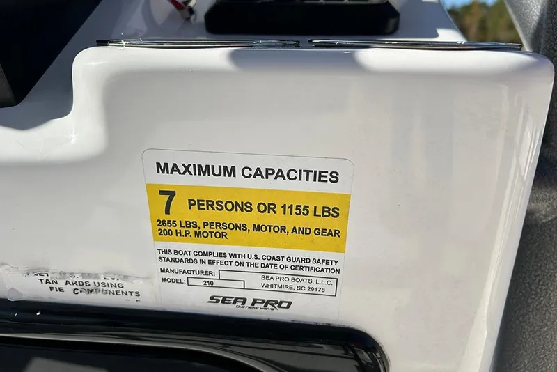 Slide: The Image of 2026 Sea Pro 210 Bay boat capacity label, 7 persons or 1155 lbs, 200 HP motor. - 51
