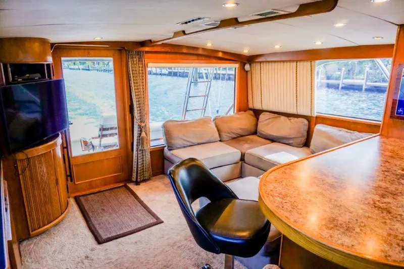 Slide: The Image of Interior of a 1987 Bertram 54 Convertible yacht with cozy seating and elegant wood finishes. - 12