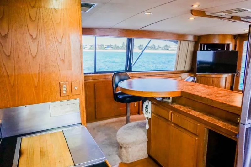 Slide: The Image of Interior of a 1987 Bertram 54 Convertible yacht with wood finishes and ocean view. - 13