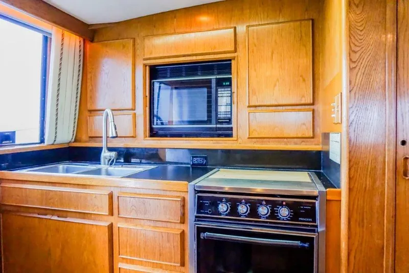 Slide: The Image of 1987 Bertram 54 Convertible yacht kitchen with wood cabinetry and modern appliances. - 16