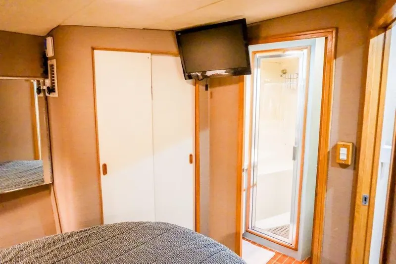 Slide: The Image of 1987 Bertram 54 Convertible interior with TV, closet, and bathroom door. - 20