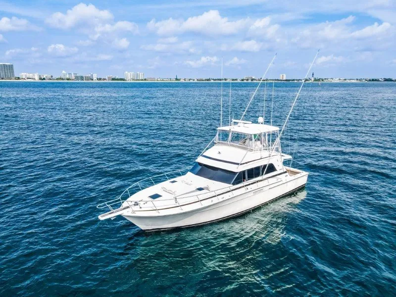 Slide: The Image of 1987 Bertram 54 Convertible yacht cruising on open blue waters under a clear sky. - 25