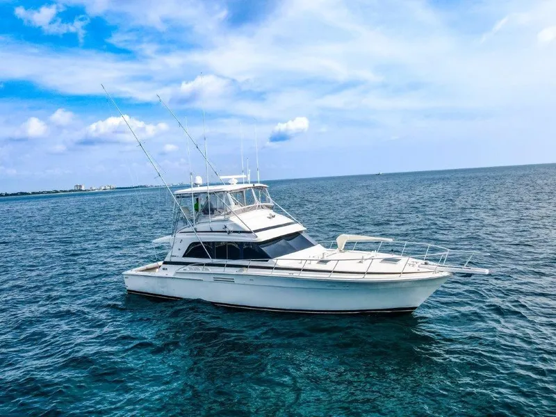 Slide: The Image of 1987 Bertram 54 Convertible yacht cruising on open sea under blue sky. - 26