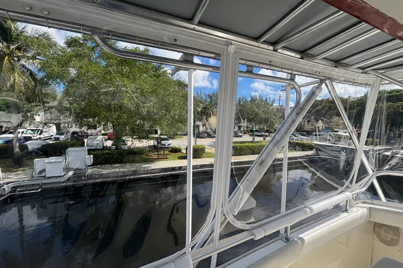Slide: The Image of 1987 Bertram 54 Convertible yacht view from interior, overlooking marina and trees. - 4