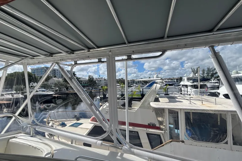 Slide: The Image of 1987 Bertram 54 Convertible yacht docked at a marina with other boats. - 5