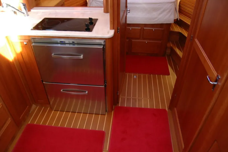Slide: The Image of Interior of 2019 Sabre 38 Salon Express yacht with modern kitchen and red rugs. - 107