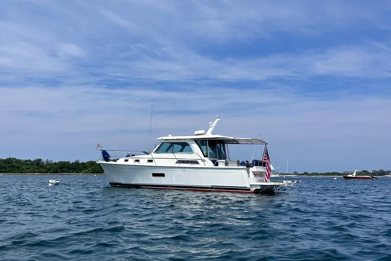 Slide: The Image of 2019 Sabre 38 Salon Express yacht on calm water under blue sky. - 12
