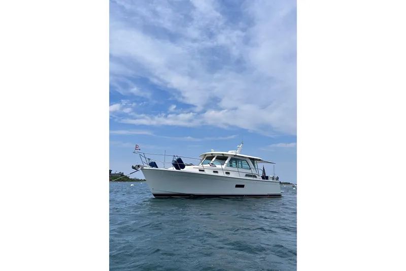 Slide: The Image of 2019 Sabre 38 Salon Express yacht on calm water under a blue sky. - 13