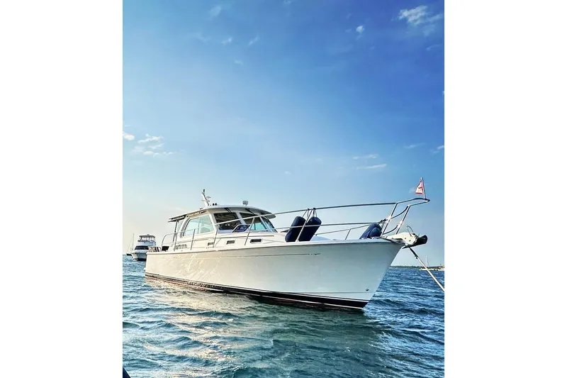 Slide: The Image of 2019 Sabre 38 Salon Express yacht on calm water under clear blue sky. - 14