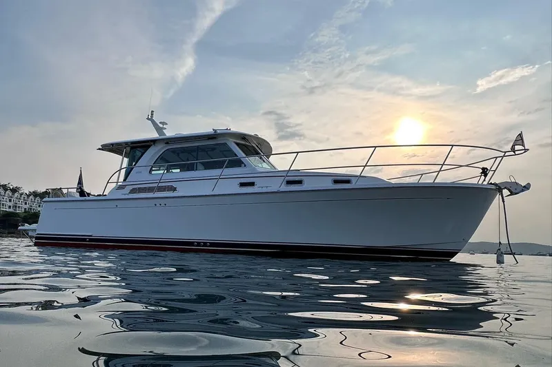 Slide: The Image of 2019 Sabre 38 Salon Express yacht on calm water at sunset. - 16