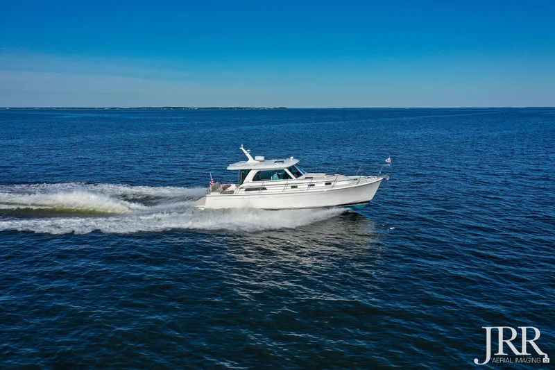 Slide: The Image of 2019 Sabre 38 Salon Express cruising on open water under clear blue skies. - 19