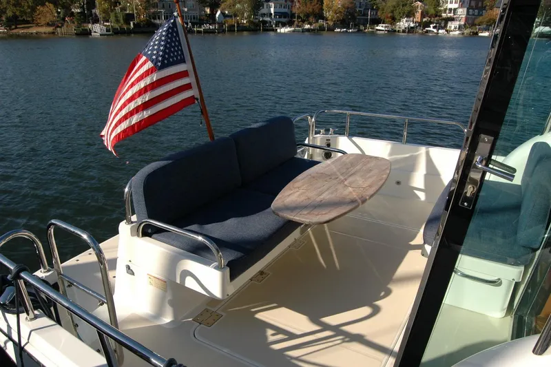 Slide: The Image of 2019 Sabre 38 Salon Express yacht deck with American flag and seating area. - 40