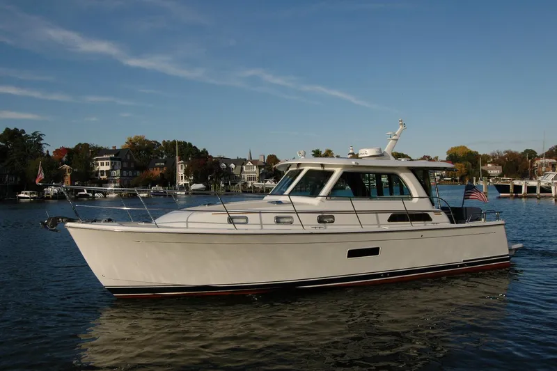 Slide: The Image of 2019 Sabre 38 Salon Express yacht cruising on a scenic waterfront. - 5