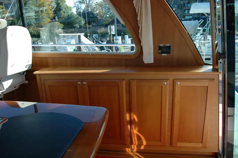 Slide: The Image of Interior of 2019 Sabre 38 Salon Express with wooden cabinetry and window view. - 62