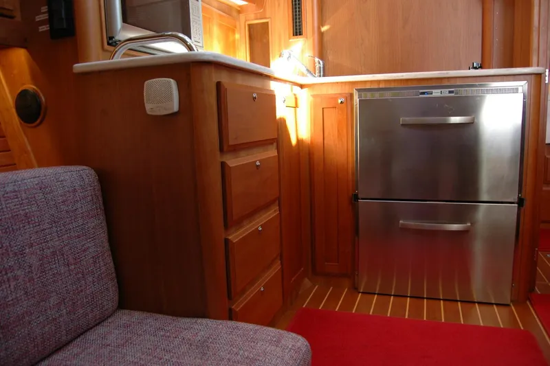 Slide: The Image of 2019 Sabre 38 Salon Express interior with stainless steel fridge and wooden cabinetry. - 86