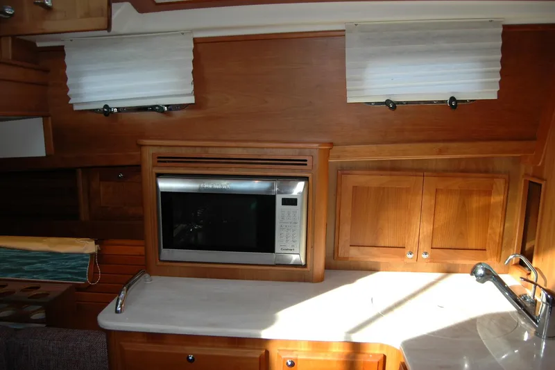 Slide: The Image of 2019 Sabre 38 Salon Express interior with microwave, wooden cabinets, and sink. - 89