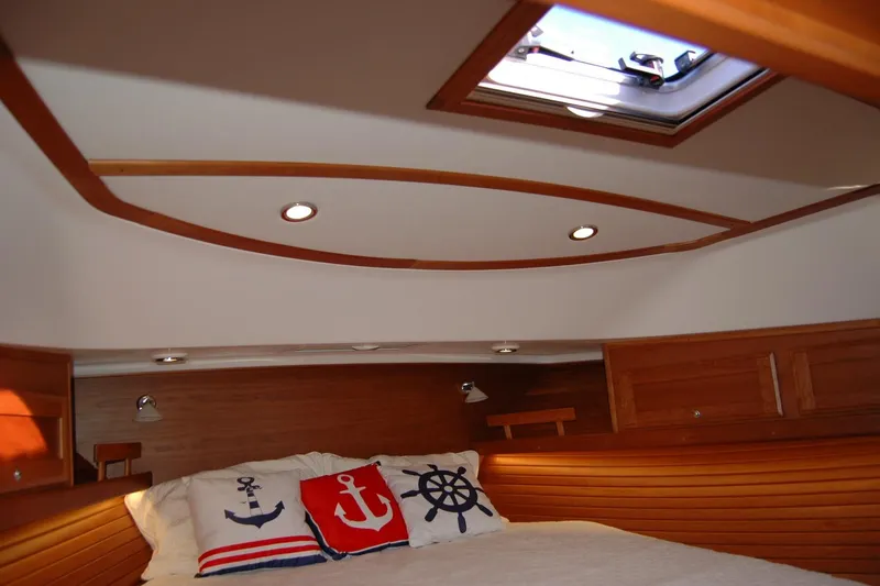 Slide: The Image of 2019 Sabre 38 Salon Express cabin with nautical-themed pillows and wooden interior. - 96