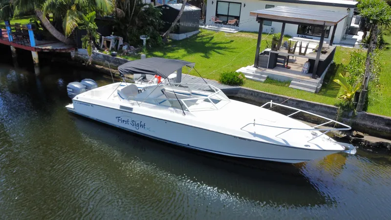 The Image of 2000 Contender 35 Side Console boat docked by a waterfront home. - 0