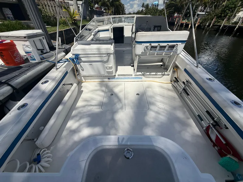 Slide: The Image of 2000 Contender 35 Side Console boat interior with seating, storage, and fishing rod holders. - 12