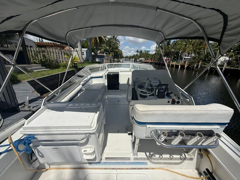 Slide: The Image of 2000 Contender 35 Side Console boat with canopy, docked by a canal. - 18