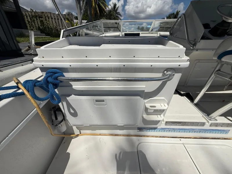 Slide: The Image of 2000 Contender 35 Side Console boat interior with storage and blue rope. - 19