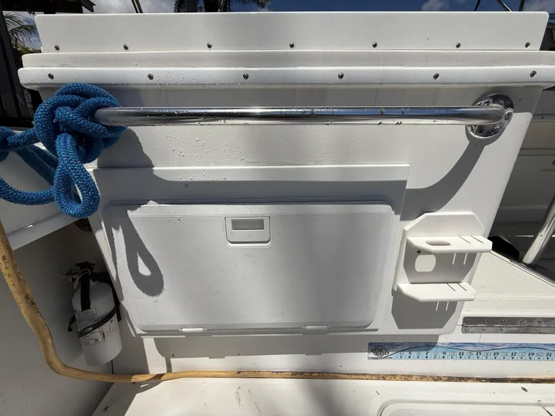 Slide: The Image of Contender 35 Side Console 2000 boat interior with blue rope and storage compartment. - 21