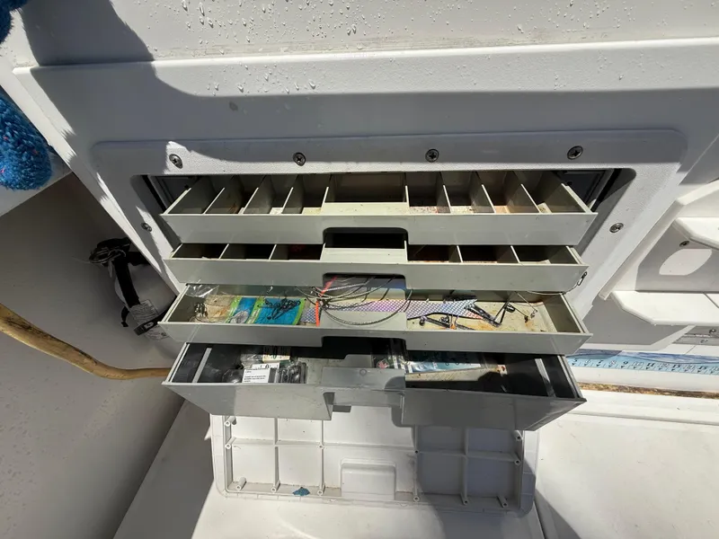Slide: The Image of Open tackle storage on 2000 Contender 35 Side Console boat, showing organized fishing gear. - 22