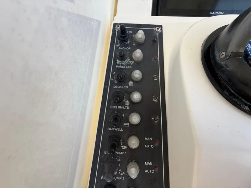 Slide: The Image of Control panel of a 2000 Contender 35 Side Console boat with various switches. - 30