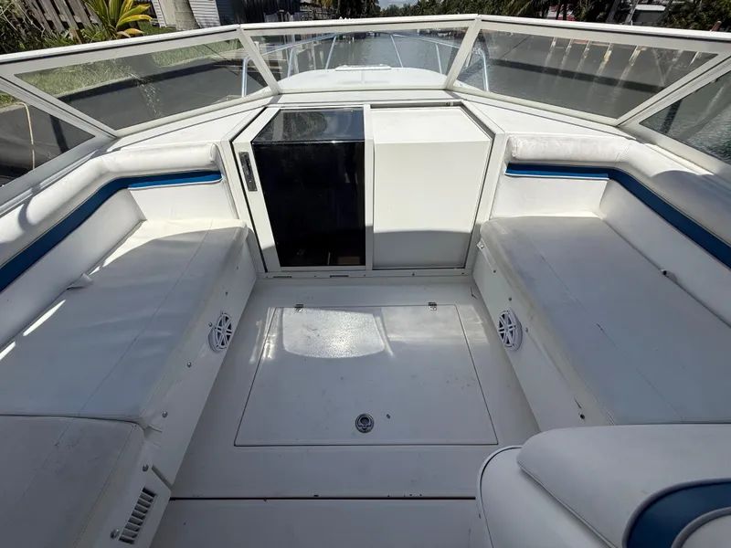 Slide: The Image of 2000 Contender 35 Side Console boat interior with white seating and storage compartments. - 36